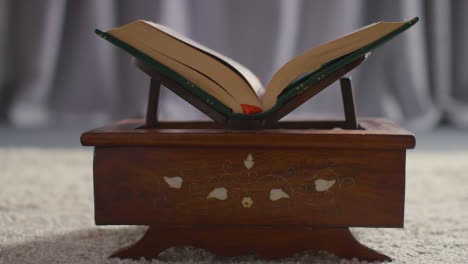 Close-Up-Of-Open-Copy-Of-The-Quran-On-Stand-At-Home-6